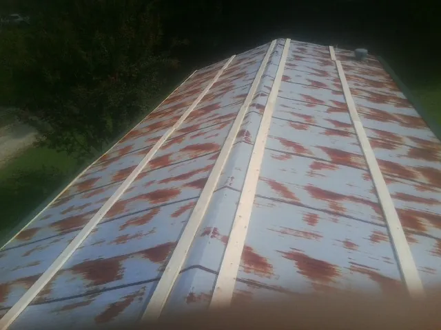 Rusted metal roof panels with new wood purlins before replacement — Storm Damage Roof Repair in Galva by Roofing Brothers