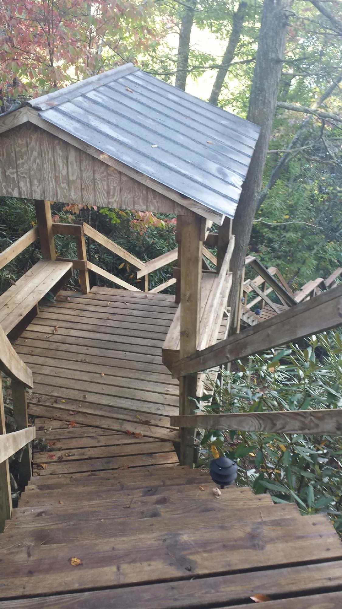 Metal roofed shelter over wooden steps on a wooded walkway — Skylight Repair & Installation work by our crew in Galva