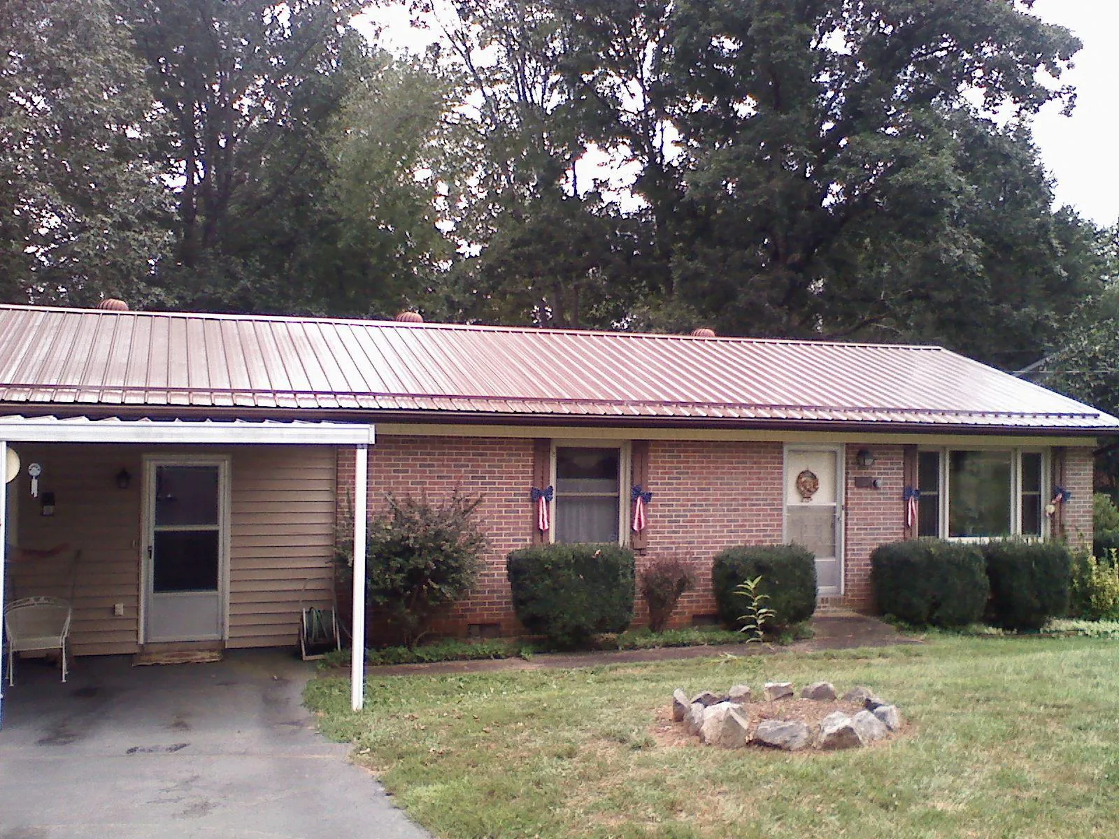 Bronze metal roof and carport on a brick ranch home — Roof Repair work by our crew in Galva